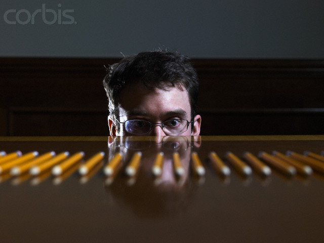 Businessman Staring at Row of Pencils