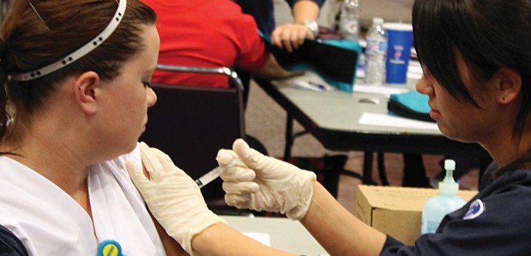 Nursing student Ashley Muscarella gives fellow nursing student, Diane Lahey her flu shot.