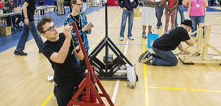 Photo by Julia Johnson Team Klopimia members from Highland High School (F to R): Josh Wagner, Gavin Hemphill and Joshua Kineke working their trebuchets while captain Adam Kelso and Judges watch.