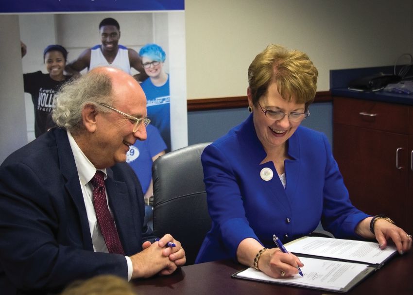 Photo by Julia Johnson Webster University President Elizabeth Stroble signs new nursing agreement with L&C President Dale Chapman.