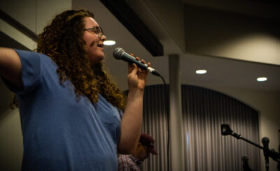 Image of student rocking out while singing karaoke during karaoke contest.