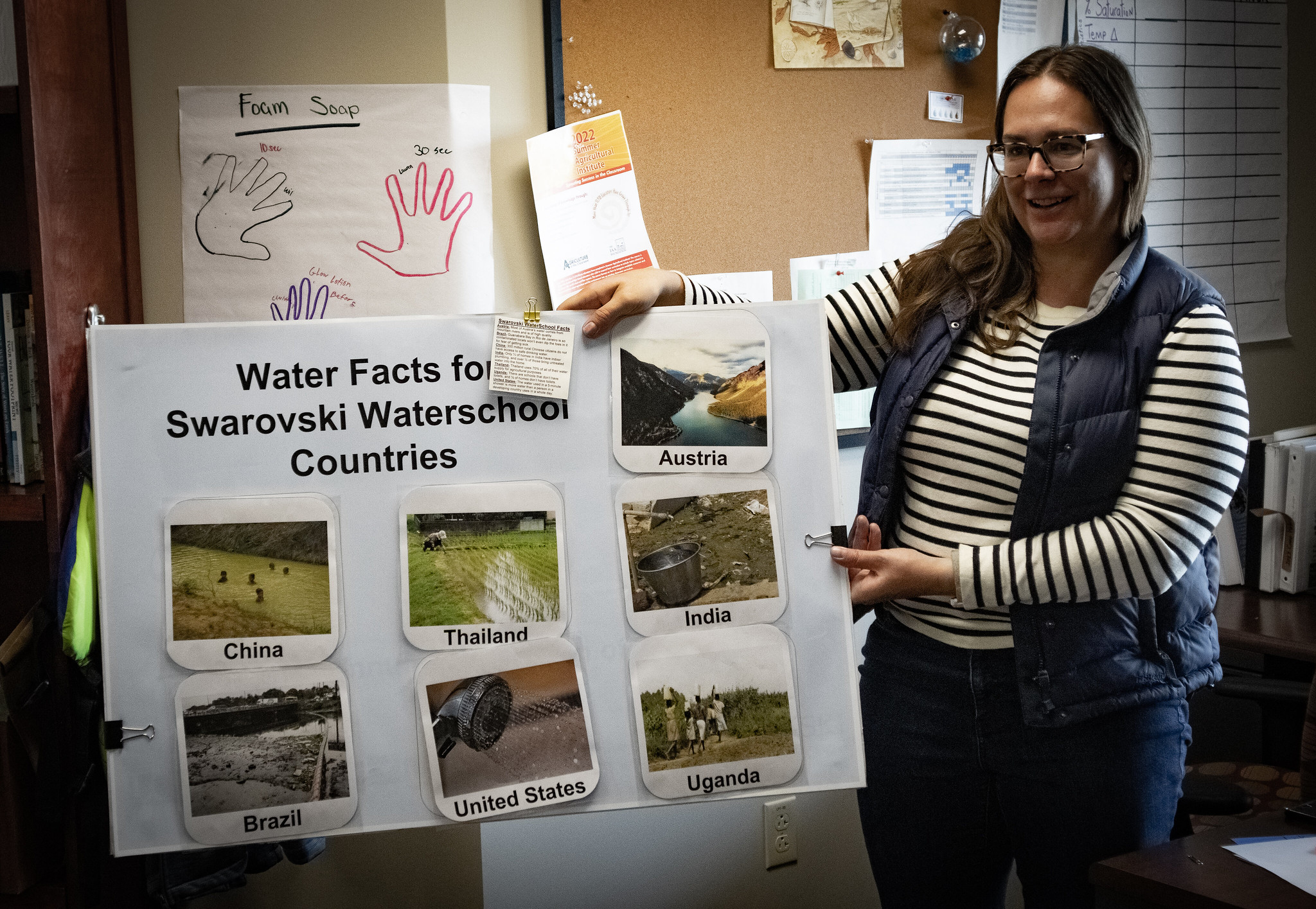 Jennifer Mandeville shows off poster about the Swarovski Water School.