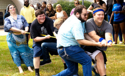 men and women enjoying a game of tug of war